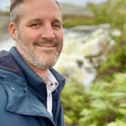 Cllr. Tom Gaydon outdoors near a waterfall in Hamsey Parish.